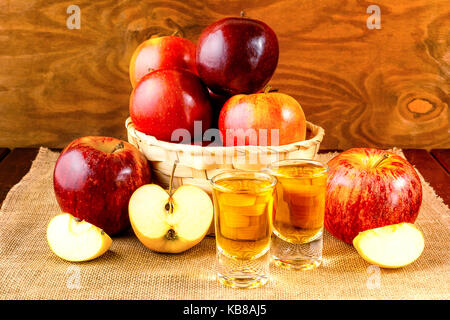 Due grappe bevande e le mele rosse nel cesto di vimini Foto Stock