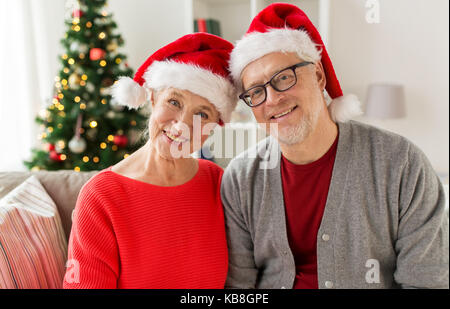 Felice coppia senior in cappelli di Babbo Natale a natale Foto Stock