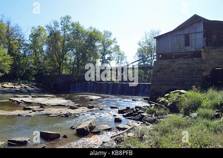 Paesaggio panoramico foto di un vecchio, abbandonato mulino di grano accanto ad una piccola cascata su un flusso. Foto Stock