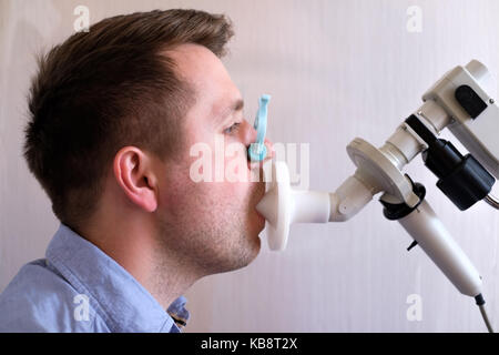 Giovane uomo test funzione di respirazione mediante la spirometria Foto Stock