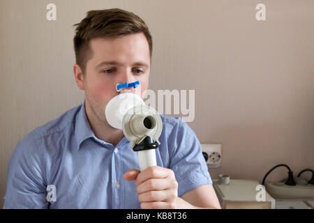 Giovane uomo test funzione di respirazione mediante la spirometria Foto Stock