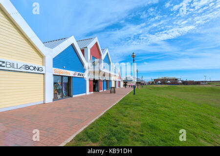 Giant beach hut style trading retail unità a Dawlish warren, devon tarda estate del sole e cieli blu, verde erba e la spiaggia e il mare in lontananza Foto Stock