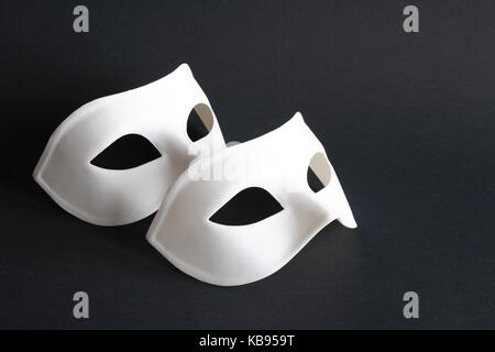 Maschere bianche e nere su sfondo ligneo vintage, simbolo dell