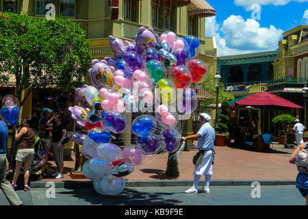Uomo che porta un grande mucchio di palloncini in Disney World theme park, Orlando, Florida, USA, gioia concetto, vita migliore concetto, mazzo di palloncini Foto Stock