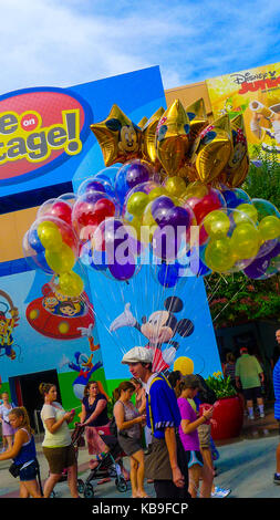 Uomo che porta un grande mucchio di palloncini in Disney World theme park, Orlando, Florida, Stati Uniti d'America Foto Stock