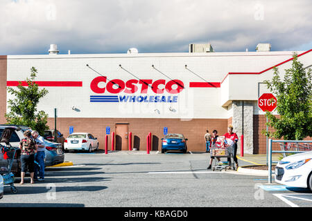 Fairfax, Stati Uniti d'America - 8 Settembre 2017: Le persone con carrelli della spesa pieni di negozi di generi alimentari prodotti a piedi fuori della Costco store in Virginia in parcheggio Foto Stock