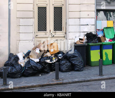 Grande mucchio di rifiuti all'interno di sacchi di colore nero e verde contenitori su strada Foto Stock