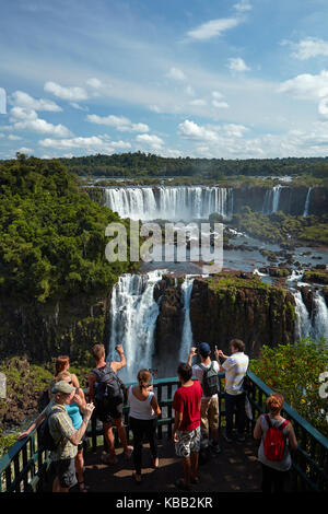 Turisti sulla piattaforma di osservazione sul lato brasiliano delle Cascate di Iguazu, guardando il lato argentino, Sud America