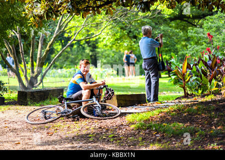 Washington DC, Stati Uniti d'America - Luglio 23, 2017: turisti gente e l'uomo con la bicicletta, ciclista, ciclista seduto a Kenilworth giardini acquatici durante il fiore di loto Foto Stock
