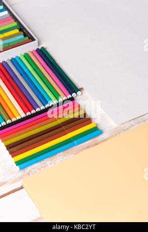 Vista dall'alto di diversi marcatori colorati nelle caselle sul tavolo bianco Foto Stock