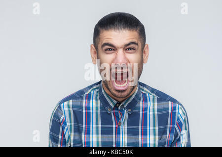 Mans ruggito! Il businessman arrabbiato, urlando con gli occhi chiusi. indoor, studio shot. sfondo grigio Foto Stock