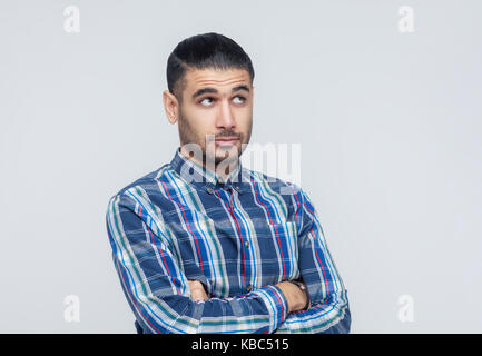 Scelta. Creatività imprenditore con barba e guardando in alto e pensare. muro grigio, studio shot Foto Stock