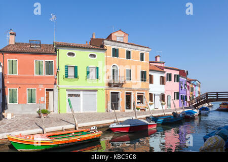 Burano, Venezia, Veneto, Italia la mattina presto luce sul case colorate e le barche con riflessioni nel canale Foto Stock
