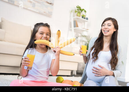 Little Girl holding mazzetto di banane Foto Stock