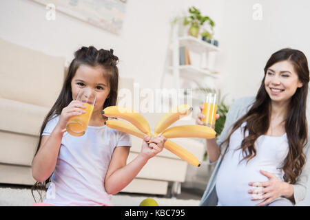 Ragazza con le banane e di bere succo di frutta Foto Stock