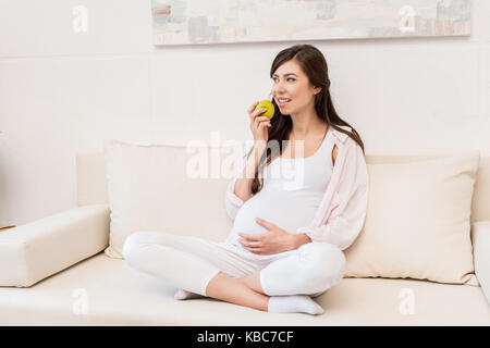 Donna incinta mangiare apple Foto Stock