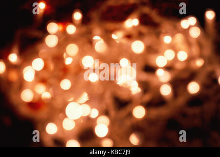 Abstract di close-up di sfocati circolari di colore arancione pallido luci di Natale prese con helios 44-2 vintage lente durante la notte Foto Stock