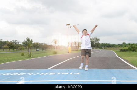 Felice asian Fat Boy in esecuzione per la riga finita., esercizio e un sano concetto Foto Stock