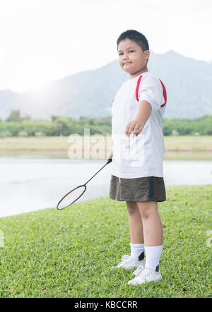 Obesi fat boy playing badminton su erba verde, esercizio e un sano concetto Foto Stock