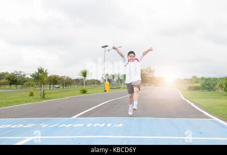 Felice asian Fat Boy in esecuzione per la riga finita., esercizio e un sano concetto Foto Stock