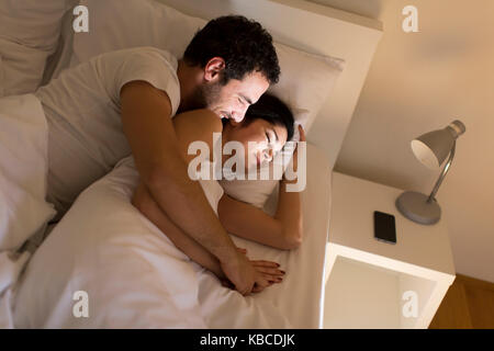 Amare giovane che dorme sul letto di casa Foto Stock