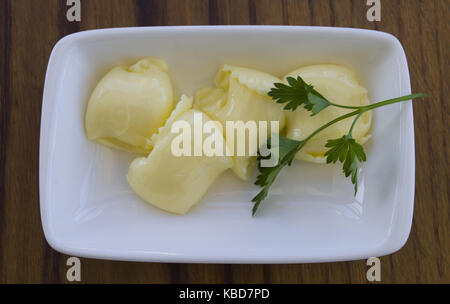 Pat di fresco burro di fattoria su un piatto di burro Foto Stock