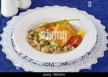 Polpette di patate con cremosa salsa di funghi in una piastra bianca su un panno blu. cibo sano concetto Foto Stock