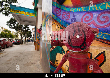 Coloratissimo graffito dipinta su un tubo antincendio e di un muro in un vicolo laterale nella missione del Distretto di San Francisco Foto Stock