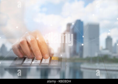 La mano viene premuto calcolatrice, ci sono sovrapposizioni di edifici e città - un concetto di business, questa immagine si concentra sulla sfocatura per essere utilizzato come backg Foto Stock