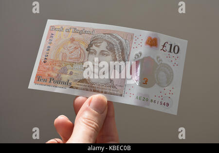 Primo piano di signora senior che tiene il nuovo polimero sterlina 10 sterlina nota con Jane Austen. Foto Stock