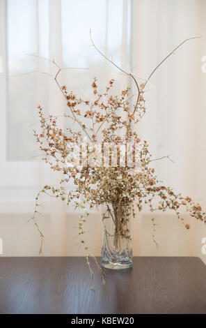 Bouquet secco di autunno piante del deserto in un bicchiere di una tabella mediante la finestra Foto Stock