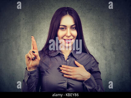 Un bugiardo sly donna che fa una promessa Foto Stock