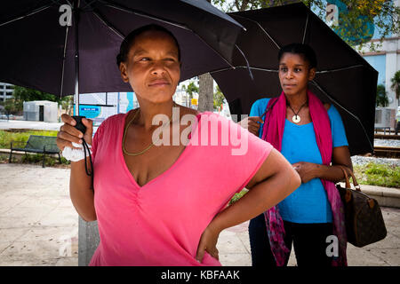 West Palm Beach, Florida, Stati Uniti d'America. 29Sep, 2017. Kimberly inverni (sinistra) e Naomi Smith attendere il loro autobus sotto la pioggia sul Nord quadriglia Boulevard Venerdì, Sett. 29, 2017, in West Palm Beach, Florida. Credito: Calla Kessler/Palm Beach post/ZUMA filo/Alamy Live News Foto Stock