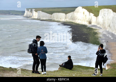 Birling Gap, East Sussex. Il 30 settembre 2017. I visitatori ai leggendari sette sorelle chalk cliffs prendere rischi per ottenere selfies sul bordo della scogliera di sbriciolamento bordo poche ore prima che passi alla spiaggia sottostante sono chiuse a causa di erosione. I passaggi devono essere chiuse il 1 ottobre, anni prima del previsto, a causa di un aumento di cliff cade. ©Peter Cripps/Alamy Live News Foto Stock