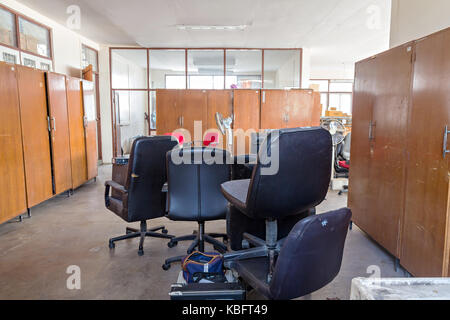 Rotture di sedie da ufficio e cabinet in legno nella camera di deposito Foto Stock