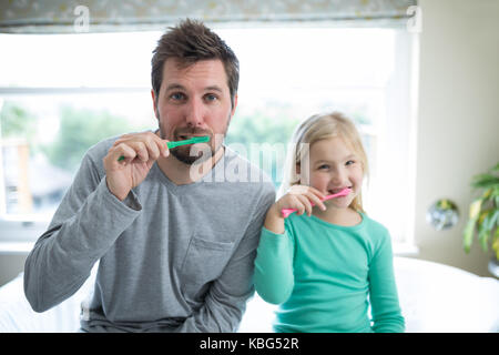 Ritratto di padre e figlia spazzolare i denti in bagno Foto Stock