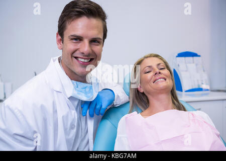 Ritratto di paziente sorridente e dentista seduti su una sedia a dental clinic Foto Stock