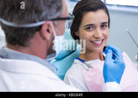 Ritratto di donna sorridente mentre riceve il trattamento dentale in cliniche Foto Stock