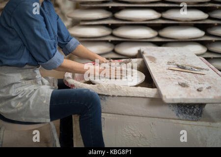 La sezione centrale del potter femmina lo stampaggio di una argilla in negozio di ceramiche Foto Stock