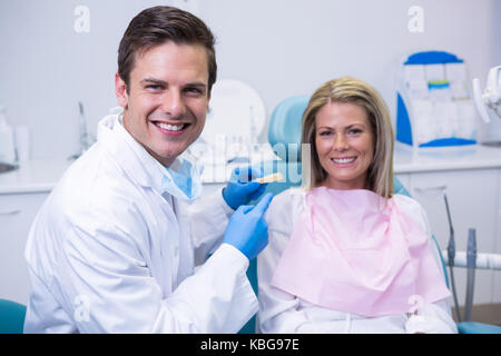 Ritratto di medico azienda stampo dentale durante la seduta dal paziente presso la clinica Foto Stock