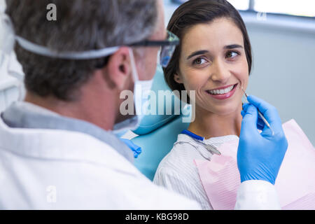 Paziente di sorridere mentre riceve il trattamento dentale a clinica medica Foto Stock