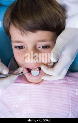 Angolo di alta vista di dentista di attrezzatura di tenuta durante l'esame ragazzo di clinica medica Foto Stock