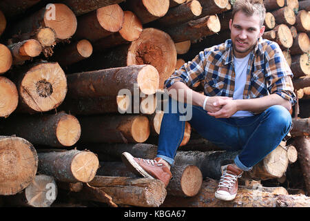 Un uomo in fabbrica lavorazione del legno, i registri di sezionatura Foto Stock