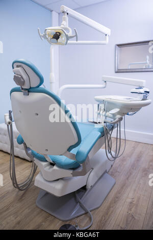 Basso angolo vista della poltrona del dentista con attrezzature mediche in clinica Foto Stock