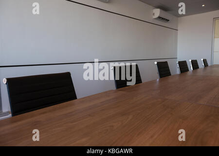 Vuoto sedie per ufficio al tavolo da conferenza in una moderna sala riunioni Foto Stock