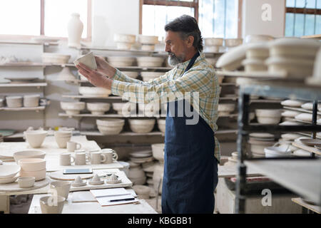 Potter maschio controllo prodotto artigianale in officina Foto Stock