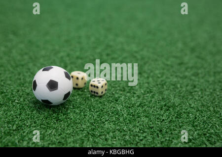Close-up di calcio e dadi su erba artificiale Foto Stock