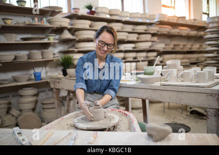 Potter femmina lo stampaggio di una argilla nel laboratorio di ceramica Foto Stock
