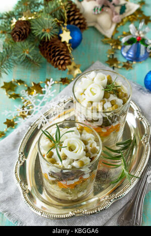 In casa vacanza snack tavola del Natale. con insalata di cetriolo marinato, patate, bastoncini di granchio, piselli verdi e uova. Foto Stock