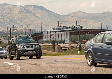 Lakewood, Colorado - un treno su 'w' linea di denver il sistema di transito rapido attraversa una superstrada. Il trasporto regionale opera del distretto di Nove ra Foto Stock